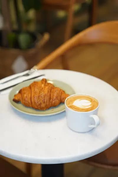 Mermer masada kruvasan ve latte