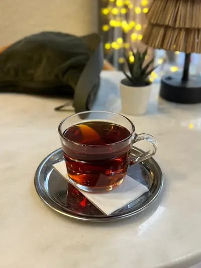 Işıkların altında ince belli bardakta çay
