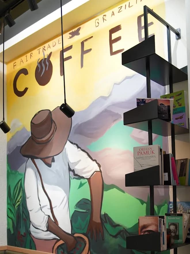Yeşil banketin arkasındaki duvar resmi ve üzerindeki Fair Trade Brazilia Coffee yazısı